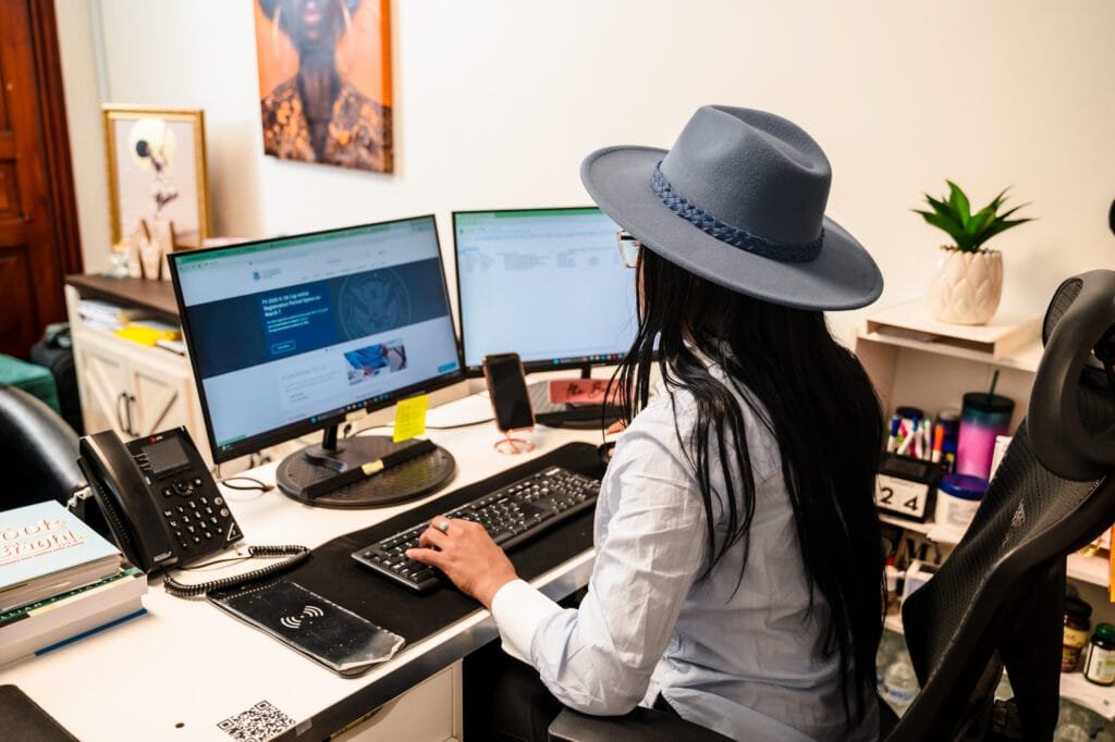 Mary Castillo working at her computer in the Mi Casa Multiservice office